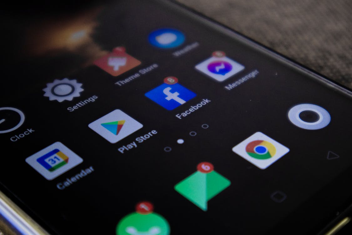 Close-up of an Android phone screen showing the Play Store alongside other apps